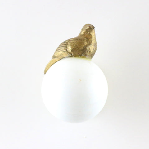White ceramic orb pull with brass bird 