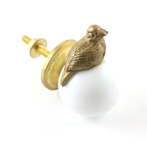 White ceramic orb pull with brass bird 