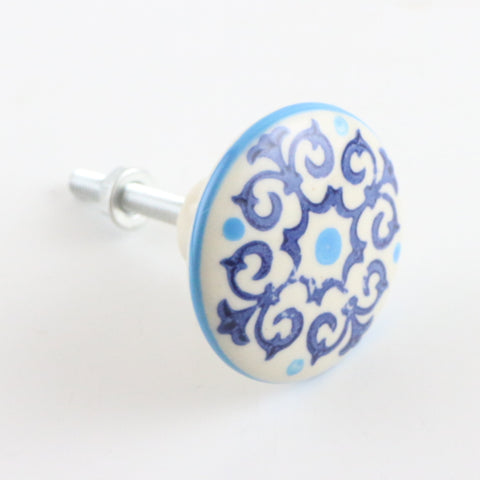 White ceramic pull with navy and turquoise scrolly pattern